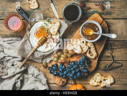 Käse, Obst, Nuss und Wein über rustikalen hölzernen Hintergrund festlegen Stockfoto