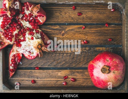 Frische reife Granatäpfel, ein Schnitt in Stücke in Holztablett Stockfoto