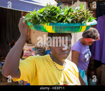 Auch in Sierra Leone sind Kartoffelblätter ein wichtiges Nahrungsmittel. Diese Frau bringt ihren Kauf mit nach Hause Stockfoto