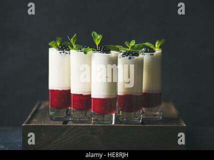 Dessert im Glas mit Brombeeren und Minze auf dunklem Hintergrund Stockfoto