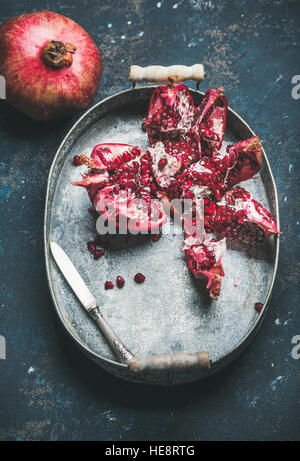 Frische reife Granatapfel in Metalltablett über dunkle Sperrholz Hintergrund Stockfoto