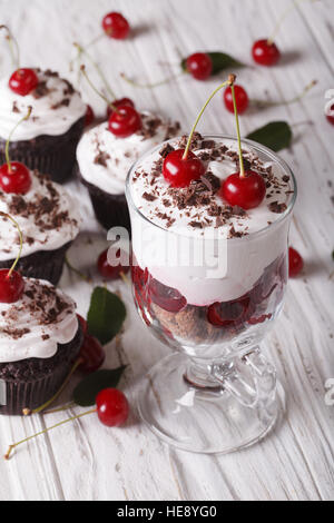 Schwarzwälder Kirsch Dessert und Cupcakes mit einer Tabelle Großaufnahme. Vertikal Stockfoto