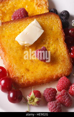 French Toast und Himbeeren und Johannisbeeren Makro auf einem Teller. vertikale Ansicht von oben Stockfoto