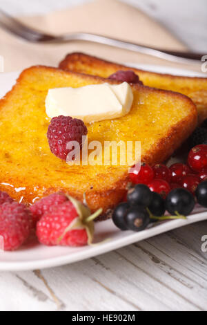 French Toast mit Himbeeren und Johannisbeeren auf eine Platte Nahaufnahme. vertikale Stockfoto