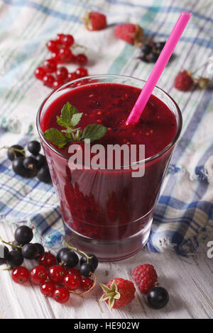 Eine leckere und gesunde Smoothies mit frischen Beeren in Großaufnahme Glas auf dem Tisch. vertikale Stockfoto