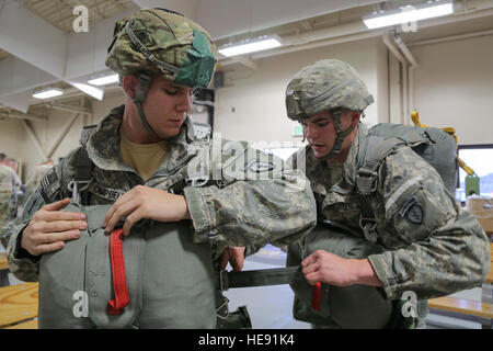 US-Armee Pfc. Gary Ballard hilft Staff Sgt Douglass Campbell, links, don seine Ausrüstung während der Vorbereitung für eine Nachtsprung an der gemeinsamen Mobilität Komplex, gemeinsame Basis Elmendorf-Richardson, Alaska, 31. März 2016. Davis, Ballard, Campbell und die Soldaten des 4th Brigade Combat Team (Airborne), 25. Infanterie-Division, die einzige amerikanische Luftlandebrigade im Pazifik gehören und sind darauf trainiert, in der Luft Manöver in extrem kalten Wetter/Höhen-Umgebungen zur Unterstützung des Kampfes, Partnerschaft und Katastropheneinsätzen ausführen. Alejandro Pena) Stockfoto