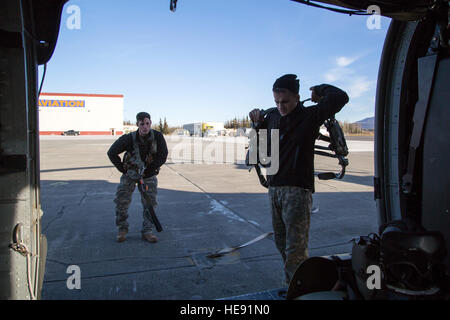 Alaska Army National Guard Sgt. Bradley McKenzie, links, und Staff Sgt Kevan Katkus, UH-60 Black Hawk Hubschrauber Crew Chiefs, 1. Bataillon, 207. Aviation Regiment zugewiesen don ihre Fluggeräte vor der Durchführung von Schulungen auf gemeinsamer Basis Elmendorf-Richardson, Alaska, 21. Oktober 2015 Rettungswinde. Die Ausbildung beinhaltete ein Dschungel-Penetrator-Gerät bereitstellen und üben eine simulierte Unfall-Evakuierung mit Soldaten, 1st Battalion (Airborne), 501. Infanterie-Regiment zugewiesen. Alejandro Pena) Stockfoto