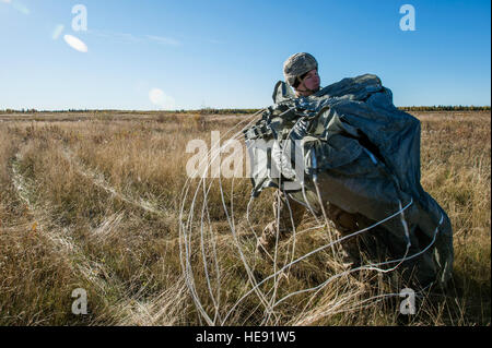 US Army Staff Sgt Walton Lowrey, gebürtig aus Ocala, Florida, Blackfoot Firma, 1st Battalion (Airborne), 501. Infanterie-Regiment, zugeordnete erholt sich seinen Fallschirm nach Durchführung einen Hubschrauber-Sprung auf Malemute Drop Zone, gemeinsame Basis Elmendorf-Richardson, Alaska, 24. September 2015. Der Fallschirmjäger führte die Ausbildung zum Verfeinern Sie ihre Fähigkeiten in der Luft einsetzen und Betriebsbereitschaft zu erhalten. Alejandro Pena) Stockfoto