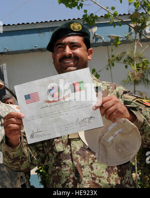 Ein Afghan National Army Soldat zeigt stolz seinen Abschluss-Zertifikat nach einer Zeremonie an einem NATO Training Mission-Afghanistan-Standort in der Nähe der Hauptstadt Kabul.  Der Soldat ist einer der 45, die den Zug der Trainer-Kurs 11. Mai 2011 abgeschlossen. Koalitionstruppen bauen der afghanischen Armee ein Gerät gleichzeitig mit Hilfe der erfahrenen Soldaten der afghanischen Nationalarmee derzeit, die nun die Rolle des Kaders füllen.  Im Durchschnitt beginnt eine afghanische Kandak ihr Training pro Woche mit einem anderen Abschluss mit der gleichen Rate.  Lt. General David M. Rodriguez, Commander, internationale Securit Stockfoto