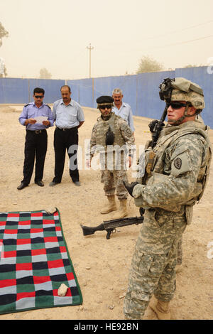 US Army Spc. Alex Rumpf aus führt das 25. spezielle Truppen Bataillon Sicherheitsabteilung, 25. Infanterie-Division, Waffen Einarbeitung training mit irakischen Polizisten aus Al Sequor Polizeistation in Al Sequor, Irak, 14 Juli. Stockfoto