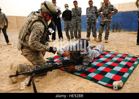 Eine irakische Polizisten zeigt richtige Ausgleichsvorgänge auf einer M240B automatischen Waffe US Army Spc Chris Walker aus der 25. spezielle Truppen Bataillon Sicherheitsabteilung, 25. Infanterie-Division, während Waffen Einarbeitung training mit irakischen Polizisten aus Al Sequor Polizeistation in Al Sequor, Irak, 14 Juli. Stockfoto