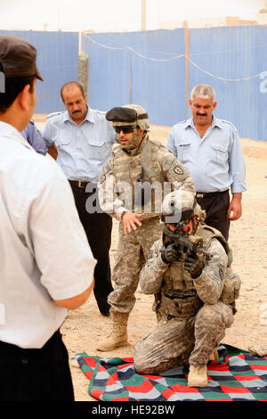 US Army Spc. Chris Walker vom 25. zeigt spezielle Truppen Bataillon Sicherheitsabteilung, 25. Infanterie-Division, die richtige Positionierung mit Hilfe von irakischen Dolmetscher während der Durchführung der Einarbeitung Training mit irakischen Polizisten aus Al Sequor Polizeistation in Al Sequor, Irak, Juli 14 Waffen. Stockfoto