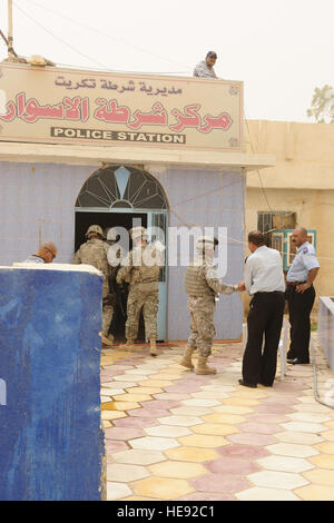 US-Soldaten vom 25. spezielle Truppen Bataillon Sicherheitsabteilung, 25. Infanterie-Division, werden von irakischen Polizisten vor der Durchführung von Waffen Einarbeitung training mit Polizisten von Al Sequor Polizeistation in Al Sequor, Irak, Juli 14 begrüßt. Stockfoto