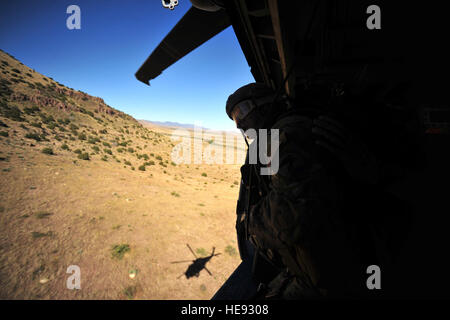 US Air Force Pararescueman Todd Popovich, zugeordnet zu den 48. Rescue Squadron Davis Monthan AFB., sucht über dem Wüstenboden nach Überlebenden während einer Suche und Rettung Mission an Bord eines Hubschraubers HH-60 Pave Hawk auf Angel Thunder 2011 am 11. Oktober 2011. Rund 1.400 US-Militär, Bundes- und Staatsbedienstete und Koalitionstruppen beteiligen sich an der 6. jährlichen Engel Thunder Übung. Angel-Thunder ist der weltweit größte Such- und Rettungsaktionen Militärübung der Welt. (USAF Staff Sgt Andy M. Kin) Stockfoto