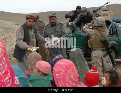 Chef der Polizei, Mohammed Masoon Farzia, händigt ausgestopfte Tiere für die Kinder von Angurdarrah Dorf, Kohe Safi, Dez. 18. (US Army Foto/Staff Sgt. Erin Tallman) Stockfoto