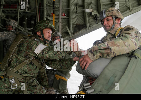 Eine japanische Ground Self Defense Force Fallschirmjäger unterstützt US Army Spc. Victor Vinnitsky, das 3. Bataillon, 509. Fallschirm-Infanterie-Regiment, an Bord eine KC-130J Super Hercules während der Durchführung von Luftlandeoperationen während Arktis Aurora 2016 auf gemeinsamer Basis Elmendorf-Richardson, Alaska, 2. Juni 2016 zugewiesen. Arktis Aurora 2016 ist eine jährliche bilaterale Übung, die Elemente der 4th Infantry Brigade Combat Team (Airborne), 25. Infanterie-Abteilung und der japanischen Boden Self Defense Force, das fördert die Interoperabilität durch die Durchführung kombiniert kleine Einheit in der Luft Kenntnisse ope Stockfoto