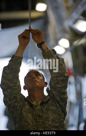 Ein Soldat mit 1st Battalion (Airborne), 501. Infanterie-Regiment, 4th Infantry Brigade Combat Team (Airborne) 25. Infanterie-Division, U.S. Army Alaska führt eine sicherheitstechnische Überprüfung an einem Fallschirm Kabelbaum Draht auf ein Transportflugzeug c-17 Globemaster III während Arctic Thunder Open House, 25. Juli 2014. Arctic Thunder Open House ist ein zweijähriger Fall gehostet durch gemeinsame Basis Elmendorf-Richardson, Alaska. Mit mehr als 40 Air Force, Army und zivilen Antenne wirkt und eine erwartete Menge von mehr als 200.000 Menschen, ist es die größte zweitägige Veranstaltung in Staat und eines der führenden Antenne demonst Stockfoto