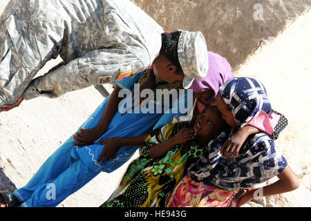 110419-F-XM360-220 DIKHIL, Dschibuti (April19, 2011) - US Army Captain Courtney Sanders, 402nd Civil Affairs Bataillon, kauert mit einer Gruppe von Mädchen vor der Dikhil High School April 19. Die Mädchen verbrachten Zeit mit Sanders Nachweis ihrer Fähigkeit, Englisch zu sprechen. Sanders führt eine sechsköpfige zivile Angelegenheiten-Team, das zusammen mit den lokalen Bürgern, die Schule renovieren bietet eine Ausbildung für etwa 700 Schüler.  Master Sergeant Dawn Preis) Stockfoto