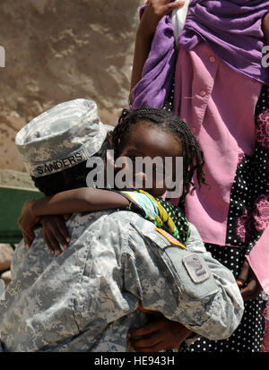 110419-F-XM360-234 DIKHIL, Dschibuti (April19, 2011) - US Army Captain Courtney Sanders, 402nd Civil Affairs Bataillon, erhält eine Umarmung von einem kleinen Mädchen vor der Dikhil High School April 19. SandersÕ zivile Angelegenheiten sechsköpfigen Team begann ihr neueste Projekt, Renovierung der High School, am 16. April. Das $10.000-Projekt wird voraussichtlich am 23. April abgeschlossen werden und direkt beinhaltet die Bemühungen der Dikhil Bürger.  Master Sergeant Dawn Preis) Stockfoto