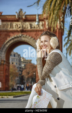 in Barcelona für einen perfekten Winter. glückliche trendige Frau in Ohrenschützer in Barcelona, Spanien mit Karte Stockfoto