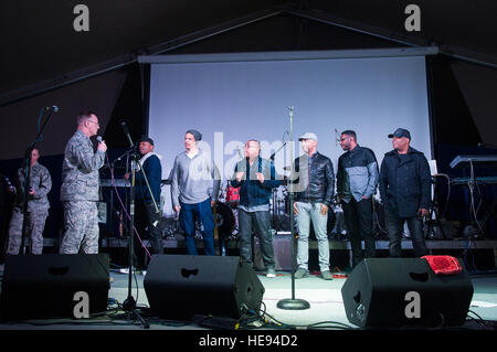 Oberst John Vaughn, 376th Air Expeditionary Wing stellvertretender Kommandant, kündigt die R & B-Band neuwertig Transit Center am Manas, Kirgisistan, 18. Februar 2014. Neuwertiger Zustand noch einen Zwischenstopp im Transit Center für US-Truppen während der Tour durchführen. Senior Airman George Goslin) Stockfoto