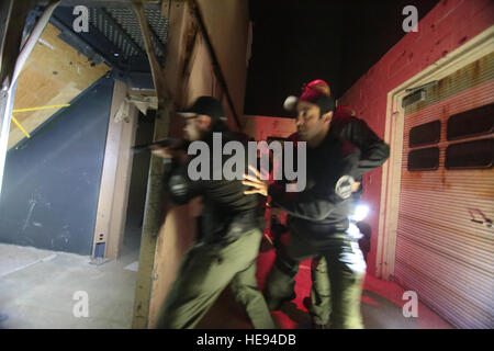 Polizisten, die Atlantic City spezielle Waffen und Taktiken (SWAT) Team zugewiesen klar einen urbanen Innenbereich in niedrigen leichte taktische Ausbildung bei gemeinsame Ausbildung und Training Development Center (JT2DC), gemeinsame Basis McGuire-Dix-Lakehurst, New Jersey Nationalgarde N.J., 14. Oktober 2016. Die JT2DC wird durch die militärischen und zivilen Behörden und ausländischen Verbündeten für Training und Funktionen der virtuellen interaktiven Bekämpfung Umwelt (Vize-), indoor militärischen Operationen im urbanen Gelände (MOUT) Immersion/Nacht kämpfen Gassen, rufen Sie für Feuer Trainer (CFFT) und Immersion Lane, Engagement Fähigkeiten Traine verwendet. Stockfoto