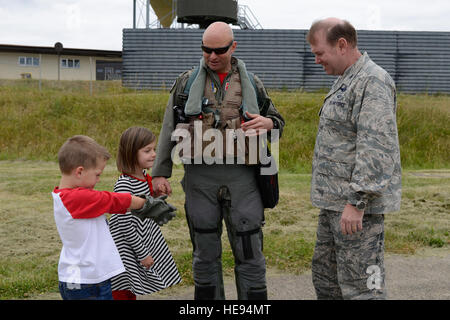 US Air Force Colonel Lars Hubert, handeln 52. Fighter Wing Commander (rechts), grüßt US Air Force Lieutenant Colonel David Berkland, 480th Kämpfer Staffelkapitän, zusammen mit seinen Kindern, Mia und Matt, nach der Rückkehr von US Aviation Detachment Rotation 14-3, 20. Juni 2014, auf der Air Base Spangdahlem, Deutschland. US Air Force Piloten beteiligte sich mit mehreren Nationen Luftstreitkräfte im baltischen Operations14, der größten jährlichen maritimen Übung im Ostseeraum. Andere Nationen, die Teilnahme an der Übung enthalten, Dänemark, Estland, Frankreich, Deutschland, Lettland, Litauen und Schweden.  Staff Sgt Christopher Stockfoto