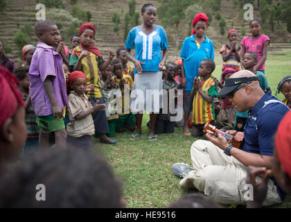 US Army Chaplain (MAJ) Lawrence Allison, kombiniert Joint Task Force-Horn von Afrika Religionsangelegenheiten stellvertretender Direktor, spielt die Ukulele Dorfbewohnern in Ostafrika, 5. April 2015.  Allison spielte mehrere hawaiische Lieder zu unterhalten und die Moral der Kinder zu steigern.  Staff Sergeant Kevin Iinuma) Stockfoto