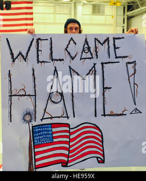 Ein Mann hält ein Willkommen Zuhause Zeichen in die Freiheit-Hangar in Hurlburt Field, Florida, 12. Januar 2014. Fast 50 US-Flieger zurückgekehrt von verteilten Standorten.  Staff Sgt John Bainter Stockfoto