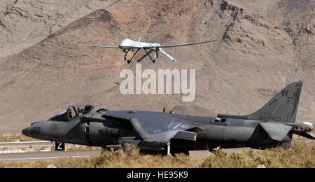 Ein US-Marine Corps AV-8 b Harrier wartet, während ein MQ-1 Predator Creech Air Force Base, Nevada 7. November landet  Mitglieder des 11. Reconnaissance Squadron es zusammen mit Marines, Marine Corps Air Station Yuma, Arizona, für eine gemeinsame Übung zugewiesen.  Senior Airman Larry E. Reid Jr.) Stockfoto