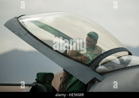 US Air Force Airman 1st Class Jay Chhoeun, zur 455. Expeditionary Maintenance Squadron versetzt, Gespräche mit anderen Flieger wie er die Haube des Flugzeuges f-16 Fighting Falcon in Bagram Air Field, Afghanistan, 22. September 2015 reinigt. Die f-16 ist ein multi-Role Kampfflugzeug, das ist sehr wendig und hat sich bewährt im Luft-Luft- und Luft-Boden-Kampf.  Techn. Sgt Joseph Swafford Stockfoto