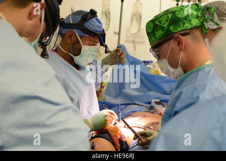 US-militärische Ärzte arbeiten zusammen, um eine Wunde eines Patienten am Craig Joint Theater Hospital, Bagram Air Field, Afghanistan 5. August 2014 zu schließen. Das Team von Ärzten verabreicht Notfall- und lebenswichtige Versorgung für die Opfer eines Vorfalls, mass Casualty.  Master Sergeant Cohen A. Young Stockfoto