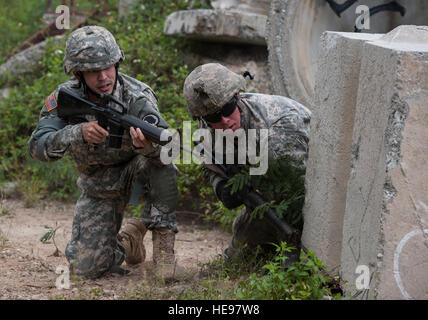 US Army Spc. Cruser Barnes (Mitte), 1. Staffel, 299. Kavallerie-Regiment, Hawaii Army National Guard (HIARNG), nimmt eine Knie hinter der Abdeckung mit Spc. Jared Okimoto, 77. Aviation Brigade, HIARNG, während eine Bewegung unter direkten Beschuss Übung im Rahmen der 2015 Hawaii Army National Guard und Reserve beste Krieger Wettbewerb 8. März 2015, im Marine Corps Training Bereich Balg, Hawaii. Konkurrenten waren acht Soldaten aus der US-Army National Guard und 13 Soldaten der US Army Reserve, die Einheiten im gesamten pazifischen Raum zugewiesen.  Staff Sergeant Christopher Hubenthal) Stockfoto