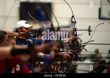 US Air Force Veteran Ryan Gallo, Zentrum, zielt darauf ab, seinen Bogen in die Bogenschießen Qualifikation entsprechen, während die Krieger Spiele 2014 in Colorado Springs, Colorado, 1. Oktober 2014. Krieger Spiele ist eine jährliche Veranstaltung, so dass Veteranen und Verwundeten, Kranken und verletzten Angehörige der paralympische Sportarten wie Bogenschießen, Radfahren, schießen, konkurrieren sitzen, Rollstuhl-Basketball, Volleyball, Leichtathletik und schwimmen.  Flieger 1. Klasse Scott Jackson, US Airforce Stockfoto