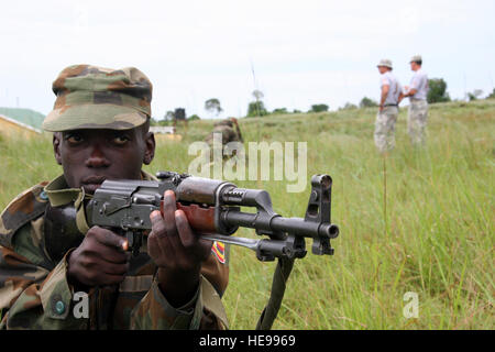 Eine ugandische Peoples Defense Force Student Soldat hält Sicherheit, während andere Mitglieder seines Teams bieten medizinischen Versorgung unter Beschuss während ein Trainingsszenario während kombiniert Joint Task Force-Horn von Afrika gegen Terrorismus Kurs gelehrt von Soldaten aus dem 1/65. Infanteriebataillon, Puerto Rico National Guard, am 23. September.  Während der Ersteres acht Wochen der Ausbildung der Studierenden wird lernen grundlegende Soldat und dann ziehen sie an militärischen Operationen urbanisiert Gelände training, wo die 1/65. Ausbilder Terrorismus Kontertechniken zeigen wird. Stockfoto