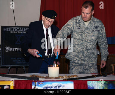 US Air Force Colonel Kenneth T. Bibb Jr., 100. Air Refueling Wing Commander, Lichter eine Erinnerung Kerze mit Harold Burgh, ein ehemaliger Offizier in der Royal Electrical and Mechanical Engineers, 28. April 2014, während eines Holocaust Remembrance Mittagessens auf RAF Mildenhall, England. Das Mittagessen kennzeichnete eine Rede von Burgh über seine Zeit als Bestandteil der Royal Electrical and Mechanical Engineers in der britischen Armee und seine Erlebnisse im KZ Bergen-Belsen in Deutschland nach seiner Befreiung im Jahre 1945.  Airman 1st Class Kyla Gifford Stockfoto