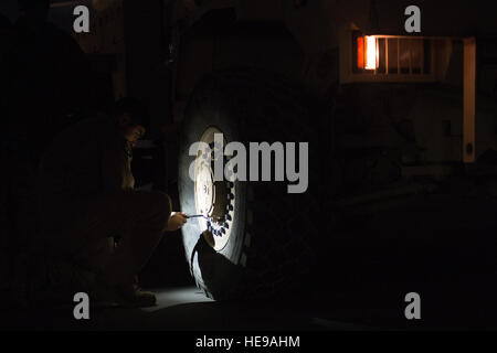 US Air Force Senior Airman Pablo Aguilar, 816th Expeditionary Airlift Squadron Loadmaster überprüft den Reifendruck auf eine Mine Resistant Ambush Protected Fahrzeug in Bagram Air Field, Afghanistan, vor dem Laden auf eine c-17 Globemaster III 23. Januar 2014. Besatzungen arbeiten rund um die Uhr um retrograde Operationen Operation Enduring Freedom, Luftbrücke Ausrüstung aus Afghanistan zu unterstützen. Ausrüstung ist zu regionalen Logistik-Hubs geflogen, wo sie dann durch Sealift an seinen endgültigen Standort gesendet wird. Aguilar gebürtig aus Las Vegas, wird bereitgestellt von der 16. Airlift Squadron, gemeinsame Basis Charleston Stockfoto