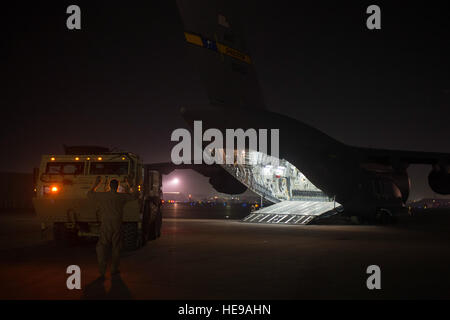 US Air Force Senior Airman Kyle Weaver, 816th Expeditionary Airlift Squadron Loadmaster Marschälle eine US Armee erweitert Mobilität taktischer LKW auf eine US Luftwaffe c-17 Globemaster III 23. Januar 2014 in Bagram Air Field, Afghanistan. Besatzungen arbeiten rund um die Uhr um retrograde Operationen Operation Enduring Freedom, Luftbrücke Ausrüstung aus Afghanistan zu unterstützen. Ausrüstung ist zu regionalen Logistik-Hubs geflogen, wo sie dann durch Sealift an seinen endgültigen Standort gesendet wird. Weaver gebürtig aus Wichita, Kansas wird bereitgestellt von der 16. Airlift Squadron, gemeinsame Basis Charleston, S.C.  Tech. Stockfoto