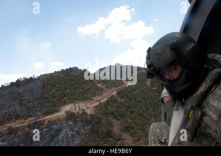 Sgt. Chris Boni, Kalifornien Army National Guard Crewchief von 1-140. Aviation Battalion (Air Assault) aus Los Alamitos gemeinsame Training Base (JFTB), gibt Wasser aus über Kopf beim kämpfen die Rim Fire in Kern County. Der UH-60 Crew übergossen die Rim Fire mit einer Gesamtfläche von 30.111 Gallonen der letzten drei Tage beim kämpfen die Kieferknochen komplexe Waldbrände zur Unterstützung des Bureau of Land Management, Kern County Fire und CAL FIRE. Stockfoto