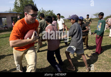 GWAILOR, Indien--Capt Jeffery Mohr einem indischen junge lehrt, wie man Fußball spielen in einem lokalen Waisenhaus während einer kürzlichen Reise nach Spielzeug Spenden und liefert an die Kinder.  Rund 130 Flieger von Elmendorf Air Force Base, Alaska, sind hier für Cope Indien ' 04, eine bilaterale Übung mit der indischen Luftwaffe.  Kapitän Mohr ist ein f-15 Eagle-Pilot mit der 19. Jagdstaffel in Elmendorf.   Techn. Sgt. Keith Brown) Stockfoto