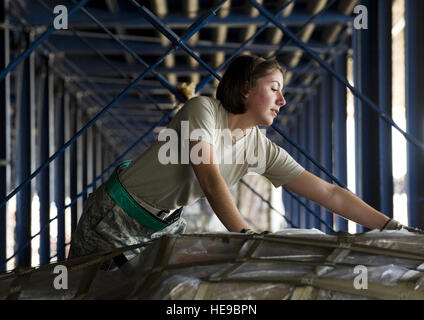 Flieger, die 1. Klasse Stephannie Grier überprüft, dass die Verrechnung auf einer Palette für ein Luftwaffenstützpunkt im Pazifik, von Travis Air Force Base, Kalifornien, am 18. April gebunden. Sie ist in der ersten Etage des zweistöckigen Palette-Storage-System. Ein erhöhter Transfer-Fahrzeug und Staff Sgt. Sherlyn Wilson. Die ETV nutzt motorisierte Rollen und Kettenfahrzeug montiert machen schnelles Arbeiten Dutzende von Paletten abgerufen werden, die die großen Körper Frachtflugzeuge zu füllen, die Travis AFB anspringen. Grier wird das 60. Antenne Port-Geschwader zugewiesen. Travis ist der führende Antenne Port für Destinationen in den Pazifik. Stockfoto