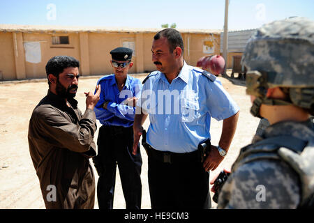 US Army 1st Lt. Julie Leggett (rechts), Executive Officer für die Sicherheitsabteilung, 25. spezielle Truppen Bataillon 25. Infanterie-Division und Irak Polizisten aus Sequor Polizeistation Gespräch mit einem Huhn Hofbesitzer während einer Mikro-Grant-Projekt-Umfrage zu beurteilen, seine Bedürfnisse, das Geschäft produktiver in der Nähe von Tikrit, Irak, 27. August. Stockfoto