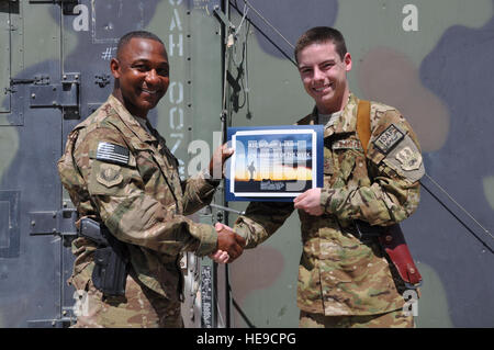 Chief Master Sgt. Kenneth Lindsey, Command Chief Master Sergeant der 455. Air Expeditionary Wing, vergibt den "Krieger der Woche"-Preis an Airman 1st Class William, 4. Expeditionary Rescue Squadron auf Bagram Air Field, Afghanistan, 11. September 2013. Stockfoto