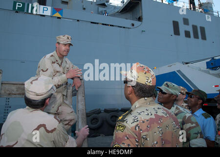 Hafen von DJIBOUTI, Djibouti (9. Mai 2012) – U.S. Navy Lt. CMdR Dustin Smiley, kombiniert Joint Task Force-Horn von Afrika maritimen Koordinierung Offizier und Verbindungsoffizier der Djiboutian Navy, Schriftsätze multinationale Koalition Offiziere vor einer Tour der USNS Carl Brashear hier 9 Mai. Brashear ist ein Lewis und Clark-Klasse aux trocken Frachter benannt zu Ehren des U.S. Navy Master Chief Petty Officer Carl M. Brashear, der erste afro-amerikanische Meistertaucher und erste US Navy Taucher auf volle Aktivaufgabe Service als einen Amputierten wiederhergestellt werden. CJTF-HOA Koalition Offiziere arbeiten neben ihrer US-cou Stockfoto