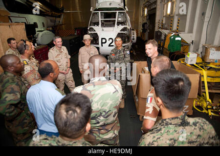 Hafen von DJIBOUTI, Djibouti (9. Mai 2012) – USNS Carl Brashear Civil Service Master Capt. Michael Grogan (oben rechts) gibt einen Überblick über das Schiff Hangar, kombiniert Joint Task Force-Horn von Afrika Personal während einer Tour hier 9 Mai. Brashear ist ein Lewis und Clark-Klasse aux trocken Frachter benannt zu Ehren des U.S. Navy Master Chief Petty Officer Carl M. Brashear, der erste afro-amerikanische Meistertaucher und erste US Navy Taucher auf volle Aktivaufgabe Service als einen Amputierten wiederhergestellt werden. CJTF-HOA Koalition Offiziere arbeiten zusammen mit ihren amerikanischen Partnern am Camp Lemonier, Dschibuti, Rela zu fördern Stockfoto