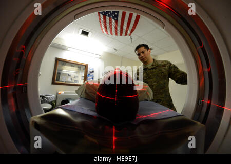 US Air Force Senior Airman Freddy Toruno, 455. Expeditionary Medical Support Squadron diagnostische Bildgebung Technologen, positioniert eine Service-Mitglied für ein CT-Scan bei Bagram Air Field, Afghanistans Craig Joint Theater Hospital, 24. Juli 2014.  Der CT-Scan hilft Radiologen, die verschiedene Arten von Krankheiten und Verletzungen, bei Schädel-Hirn-Verletzungen zu diagnostizieren. Toruno wird bereitgestellt von Travis Air Force Base, Kalifornien, und ein Eingeborener von Miami.   Staff Sgt Evelyn Chavez Stockfoto