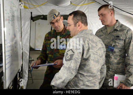 Belgische Streitkräfte 1. Lt. Daniel Van Eyck, links, stellvertretender Offizier verantwortlich für kombinierte Bemühung 2013 Mission Gruppe 1 und zwei US-Flieger mit 606th Air Control Squadron dienen als Mitglieder einer US-Delegation Voice-over Internet-Protokoll-Funktionen im U.S. Army Garrison Grafenwoehr in Deutschland 14. September 2013 diskutieren. Kombinierte Bemühung ist eine jährliche Führungs-, Kommunikations- und Computer-Systeme (C4) Übung entwickelt, um internationale Kräfte für multinationale Operationen im Europäischen Theater vorzubereiten.  Techn. Sgt Kenia Shiloh Stockfoto