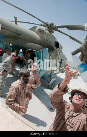 US Air Force Major William Ashford, Offizier vom Dienst, 441sten Air Expeditionary Advisory Squadron, reicht für eine Packung mit Mineralwasser zu übergeben und laden auf ein MI-17 Hubschrauber, Sept. 5, während einer Nahrung Nachschub Mission in Kandahar Air Wing, Kandahar Airfield, Afghanistan. US-Flieger und Soldaten und afghanische Soldaten arbeiteten zusammen, um einen 5. Kandak afghanische Grenzpolizei Check Point in Shorabak Bezirk 137 Fälle von Wasser- und Halall Mahlzeiten anzubieten. Ashford ist Orange, Calif., bereitgestellt von Headquarters Air Force Global Strike Command, Barksdale Air Force Base, La. Stockfoto