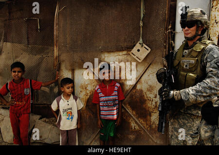 US Armee Sgt. Mark Speakman, gebürtig aus Sacramento, Kalifornien, zieht Sicherheit als irakische Kinder Armbanduhr, im Stadtteil Jefrmila von Ghazaliyah, Irak am Sep 5, 2008 US-Soldaten sind Teil der 2. Zug, Bravo Truppe, 1. Staffel, 75. Kavallerie, 101. US-Luftlandedivision.  Staff Sgt Manuel J. Martinez Stockfoto
