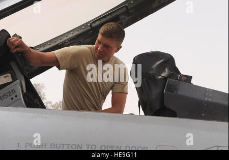 JOINT BASE BALAD Irak – Senior Airman Travis Goll, 332. Expeditionary Aircraft Maintenance Squadron f-16 Crewchief stellt Schutzhüllen auf dem Sitz und Hands-Up-Display im Cockpit einer f-16 Fighting Falcon hier 1.Mai. Die Abdeckungen die Anzeige und Sensoren frei von Staub um sicherzustellen, dass das Gerät ordnungsgemäß arbeitet.  Airman Goll wird hier von Hill Air Force Base in Utah, bereitgestellt und stammt aus Garner, Iowa. Senior Airman Elizabeth Rissmiller) Stockfoto